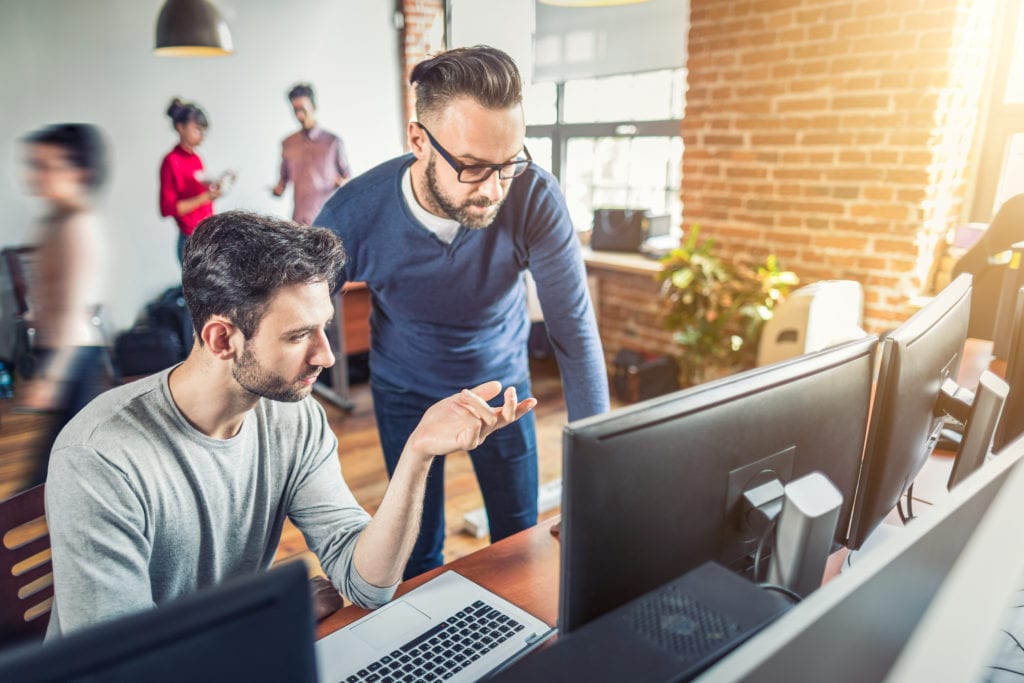 barcom technology solutions team working together at computer in modern office